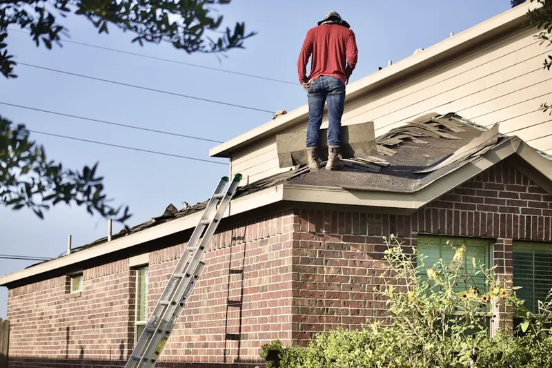 Professional roofer working on a residential roof in Sandy